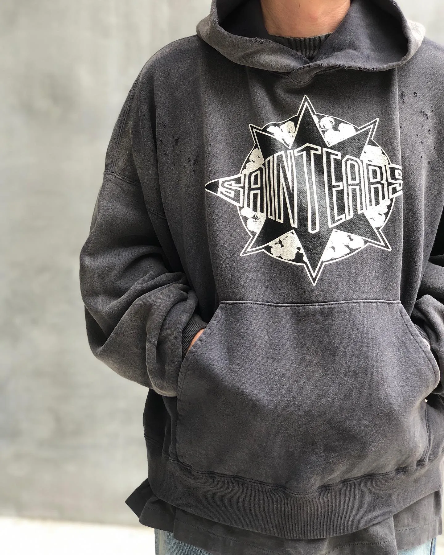 DENIM TEARS x SAINT Mxxxxxx SAINT TEARS Hoodie/BLK Five-pointed star cotton hole-in-the-dark distressed hoodie, washed black S-XL Assute dyeing, whole piece sprayed with horse fade/horse weight, co-branded main mark/cotton wash mark/cherub mark, many hanging holes on the front and rear panels, the original version has the same loose fit